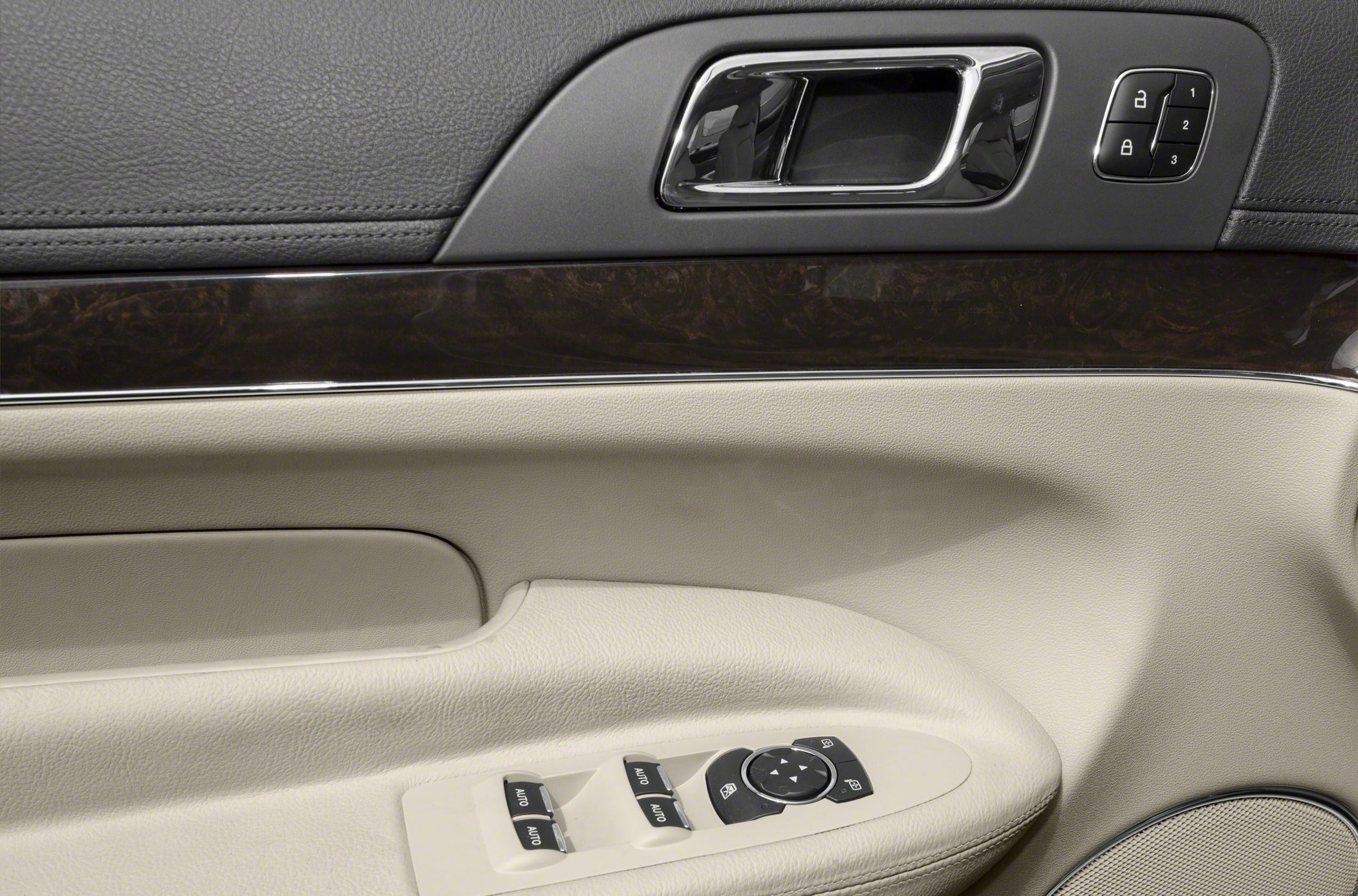 Chrome door handle, wood trim, door lock & window control buttons on beige panel