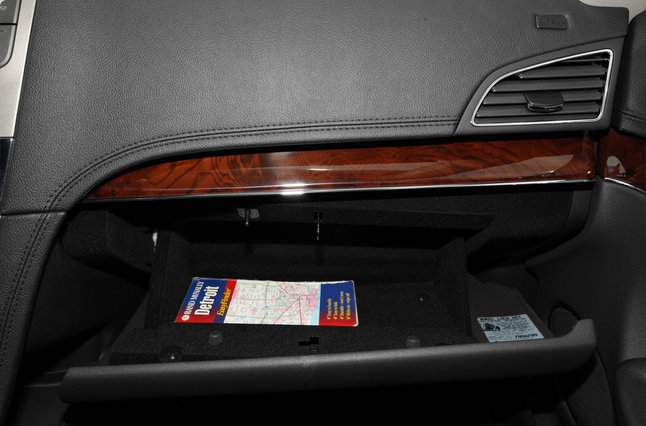 Open glove compartment with wood trim and air vent detail