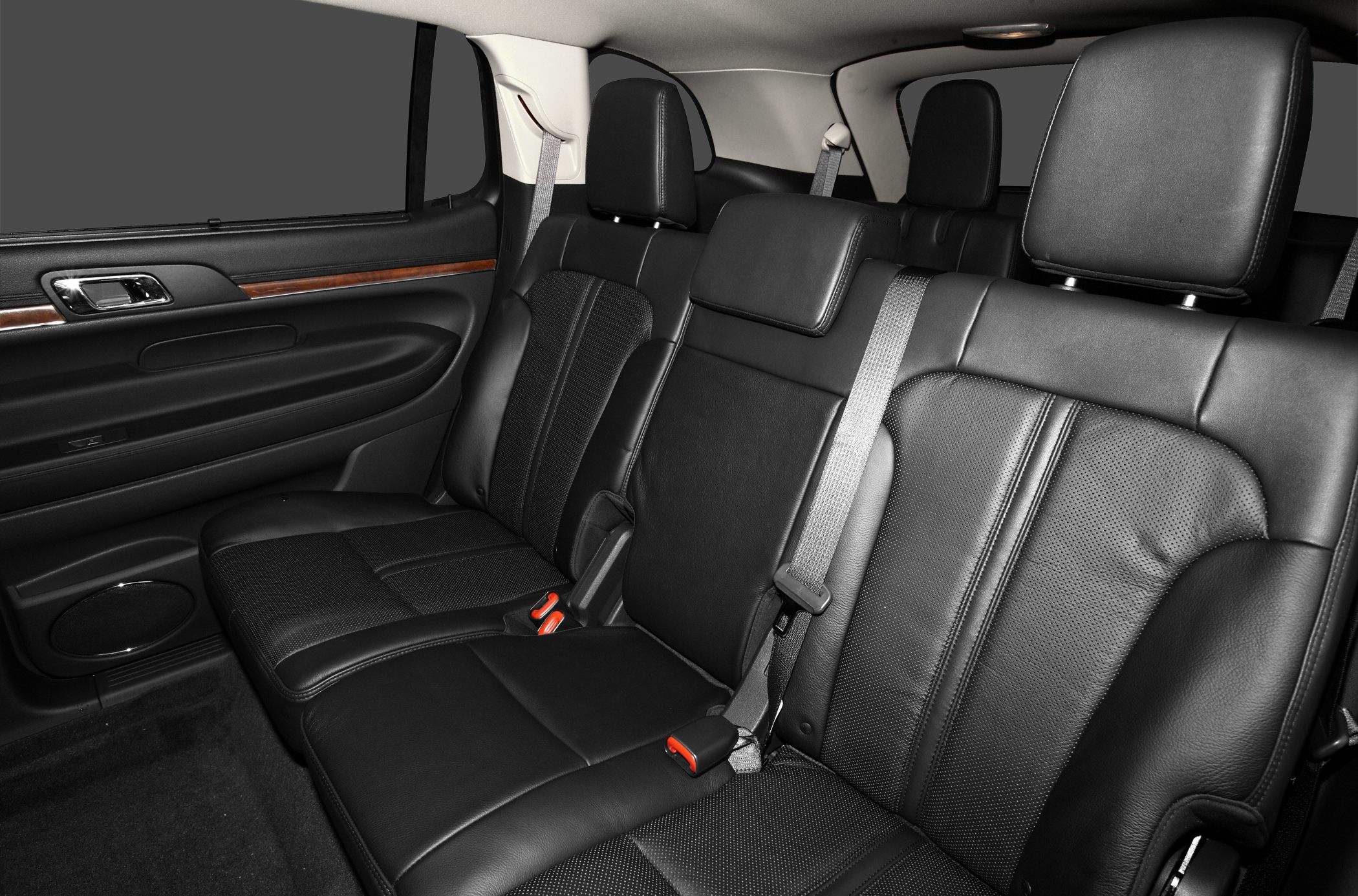 Black leather rear seats with seatbelts and wood trim in spacious SUV interior