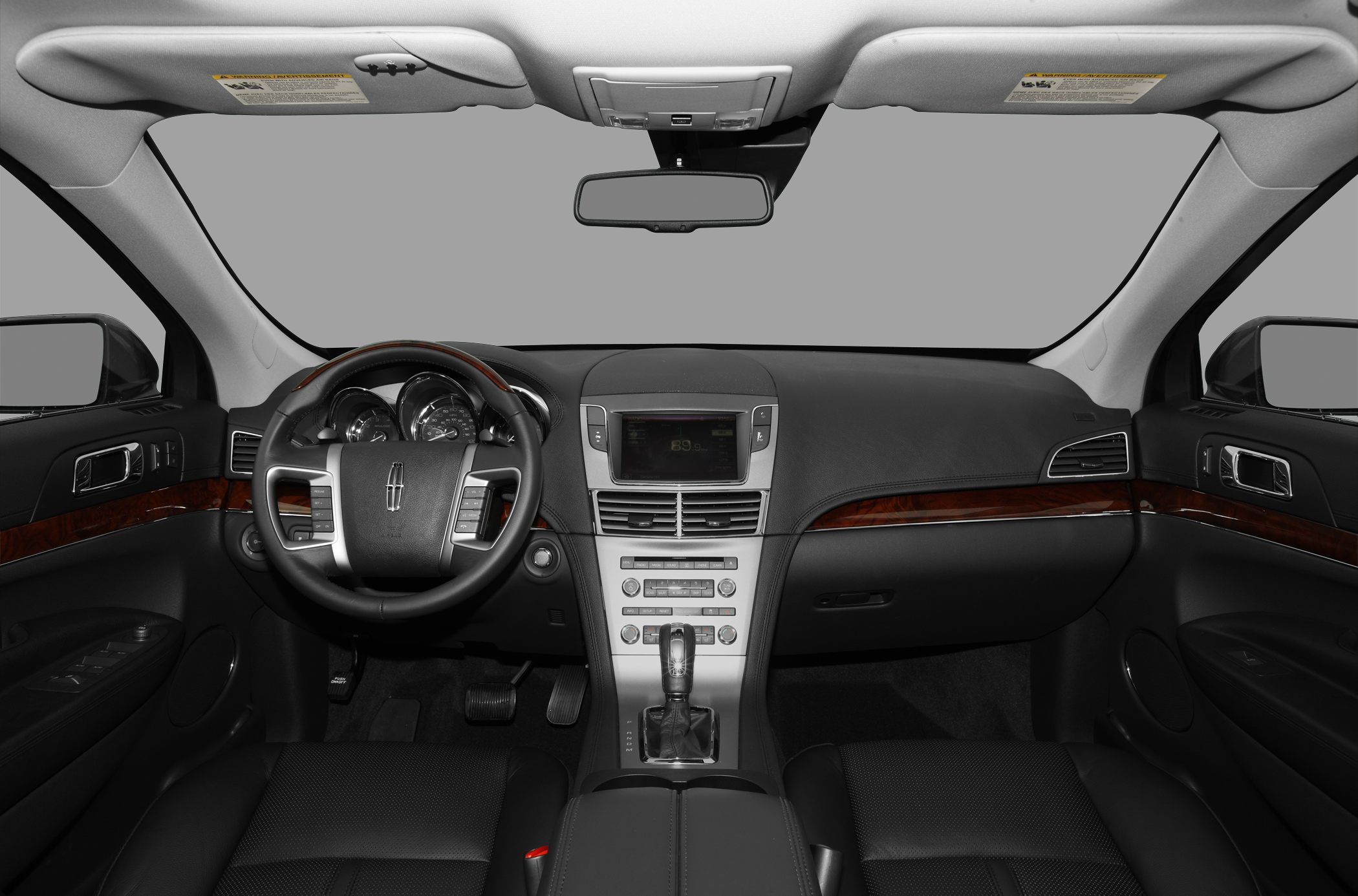 Dashboard with central touchscreen and steering wheel with control buttons, wood trim accents