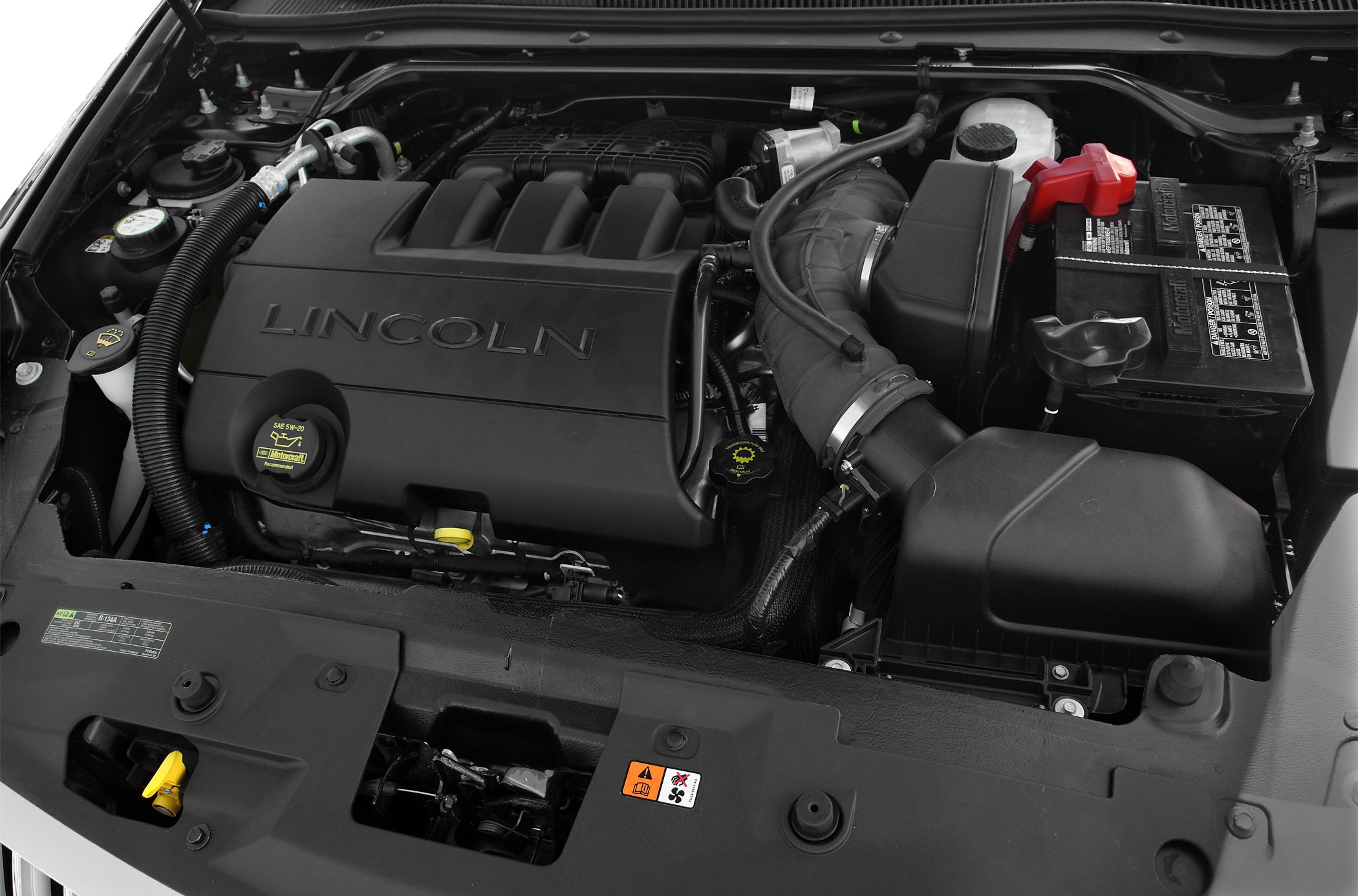 Close-up of engine bay showing engine cover, battery, and air intake system