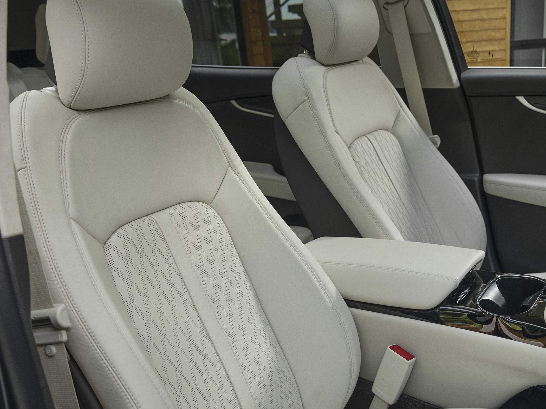 Luxury perforated leather seats with detailed stitching and central armrest