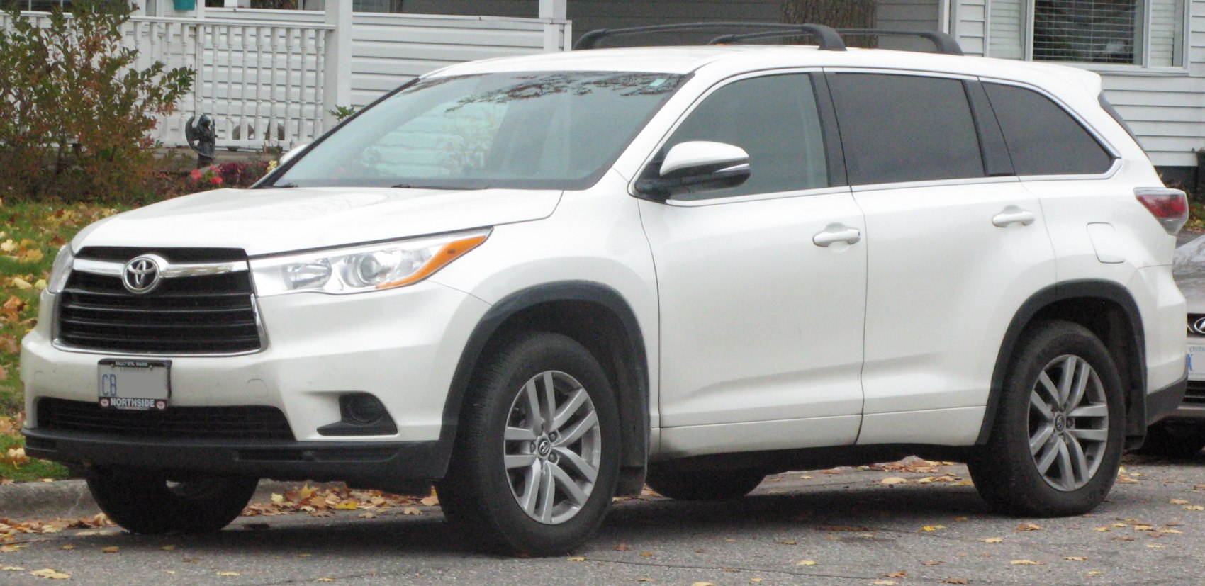 White midsize SUV front side with roof rails and alloy wheels