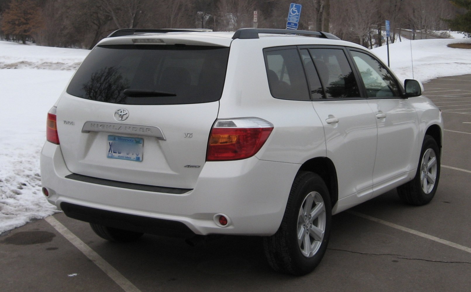 Rear side view of white SUV with roof rails and alloy wheels