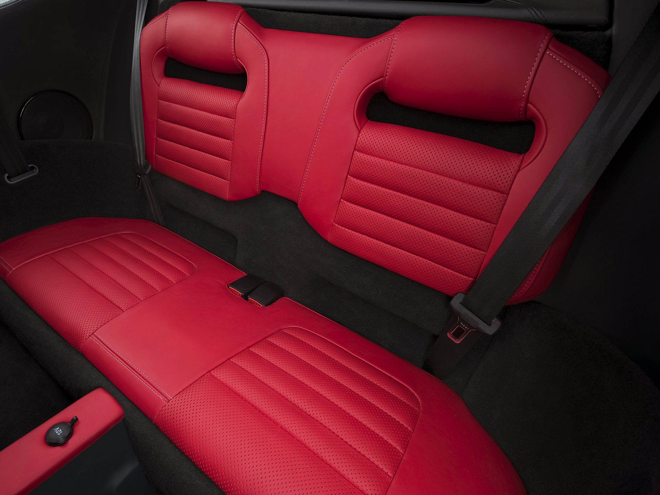 Red leather rear seats with detailed stitching and seatbelt