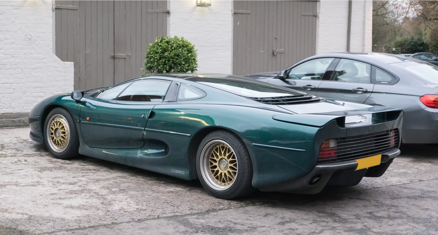 Green sportscar side and rear with gold alloy wheels