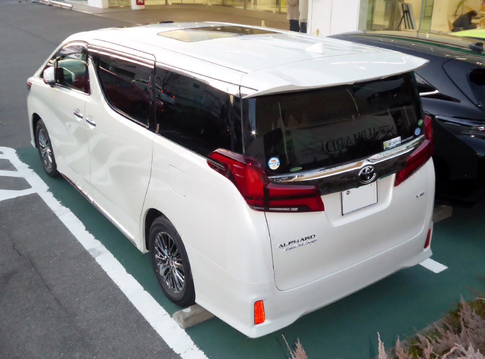 Rear view of white luxury minivan with tinted windows and distinct rear lights