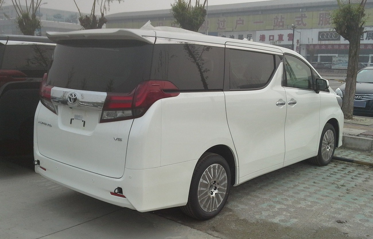 White luxury minivan rear side view with tinted windows and sliding doors