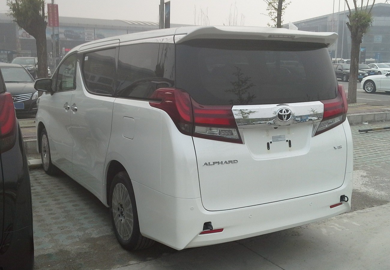 Minivan rear view with curved tail lights and chrome trim