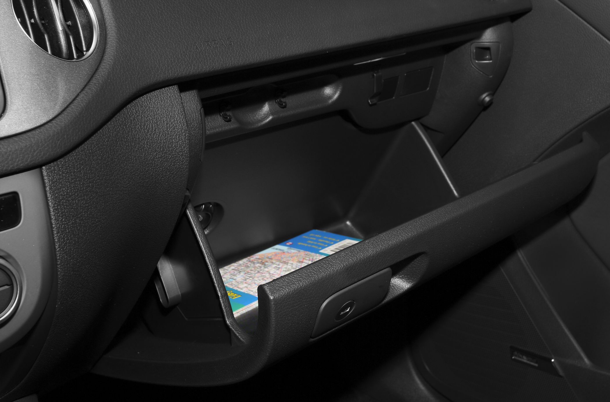 Open glovebox storage compartment with dashboard detail