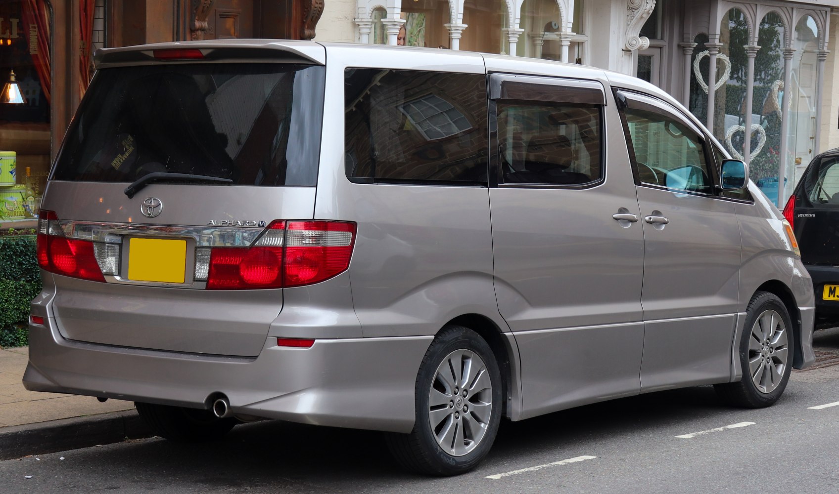 Rear view of silver minivan with distinctive taillights and alloy wheels