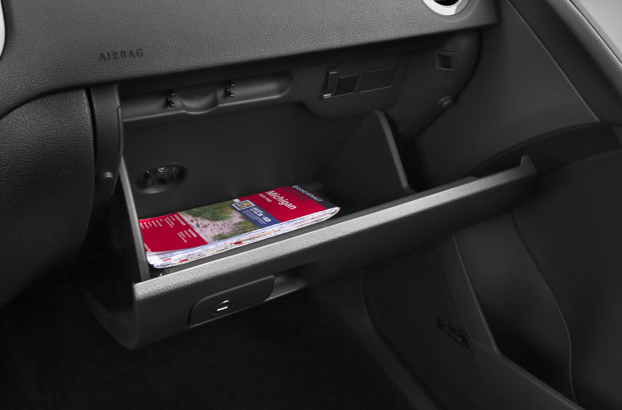 Open glove compartment with brochure in a 2012 facelift car interior.