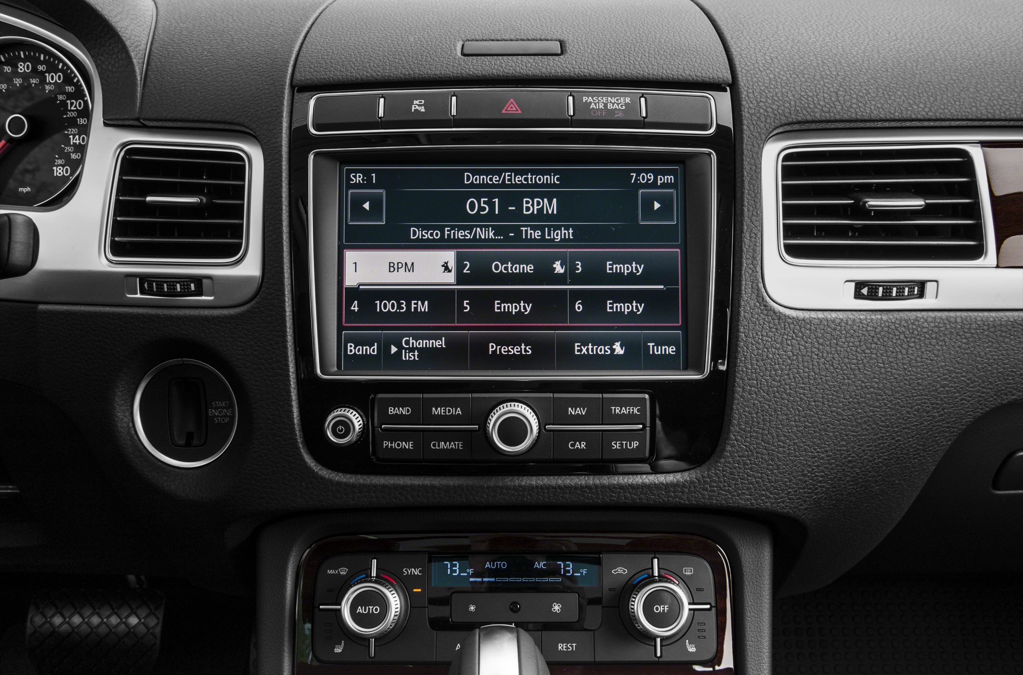 Dashboard infotainment screen with radio presets and dual-zone climate controls.