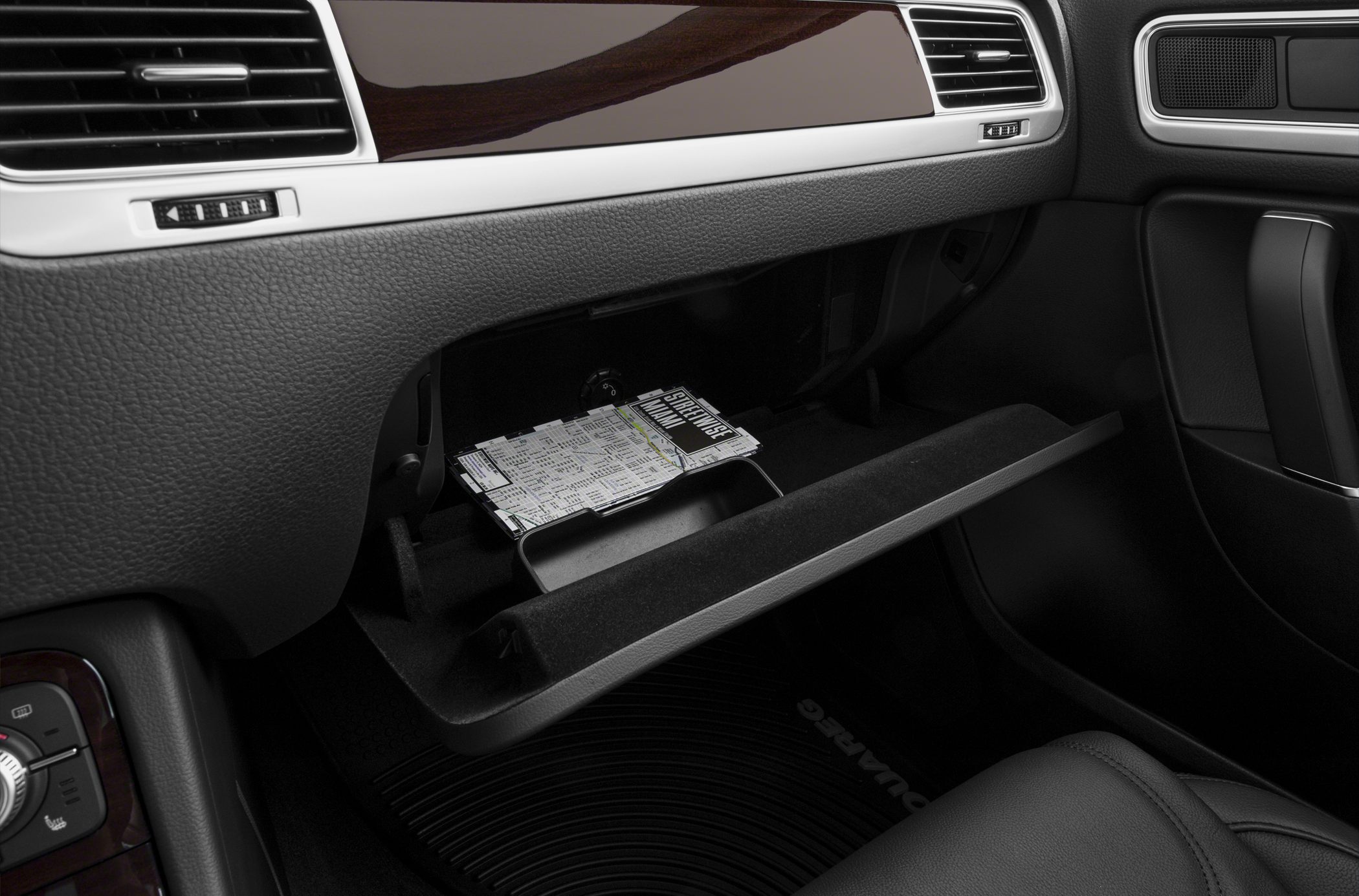 Open glovebox and dashboard with wood trim and air vents