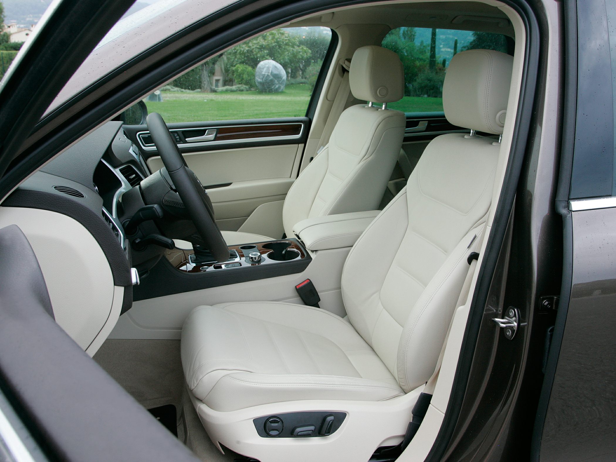 Luxury beige leather front seats with electric controls and wood trim interior