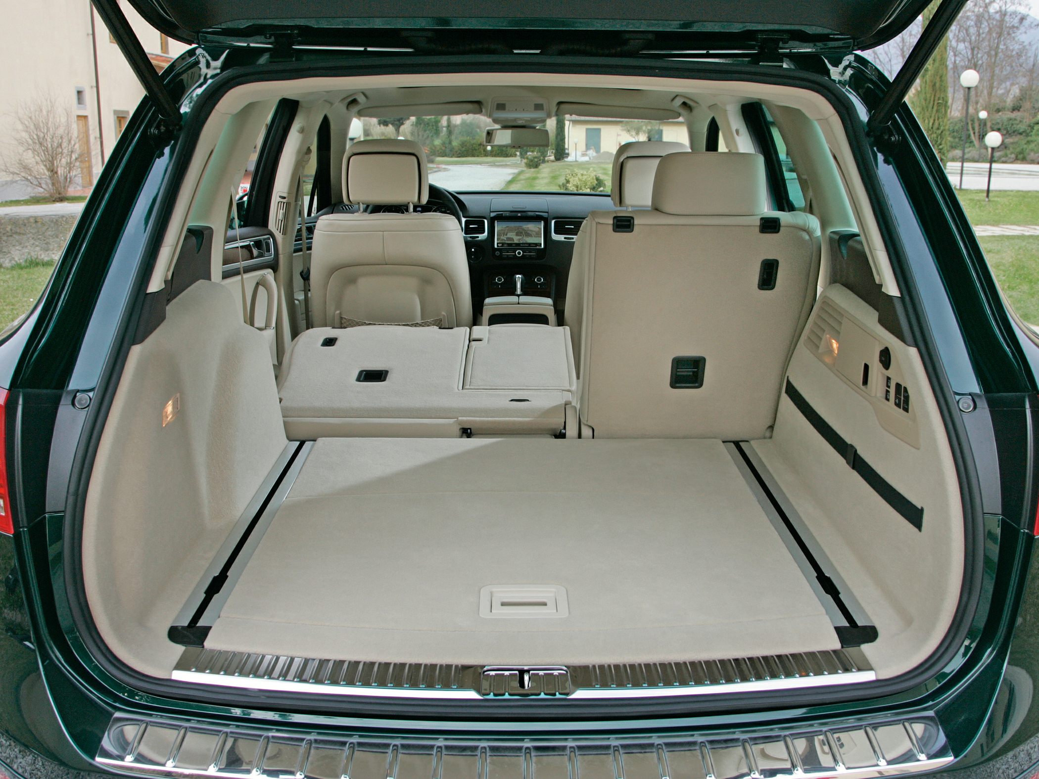 Rear cargo space with fold-flat seats and beige upholstery in SUV.