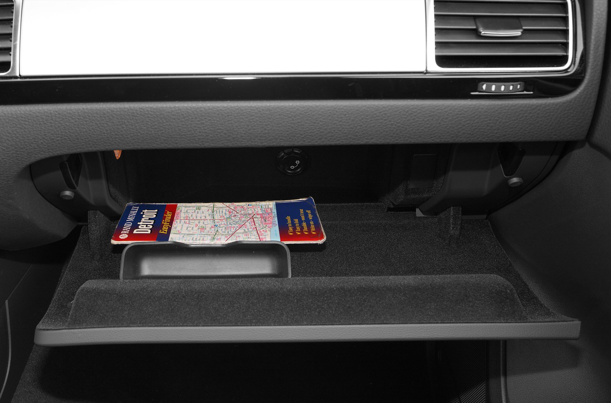 Open glovebox with folded map inside in car interior