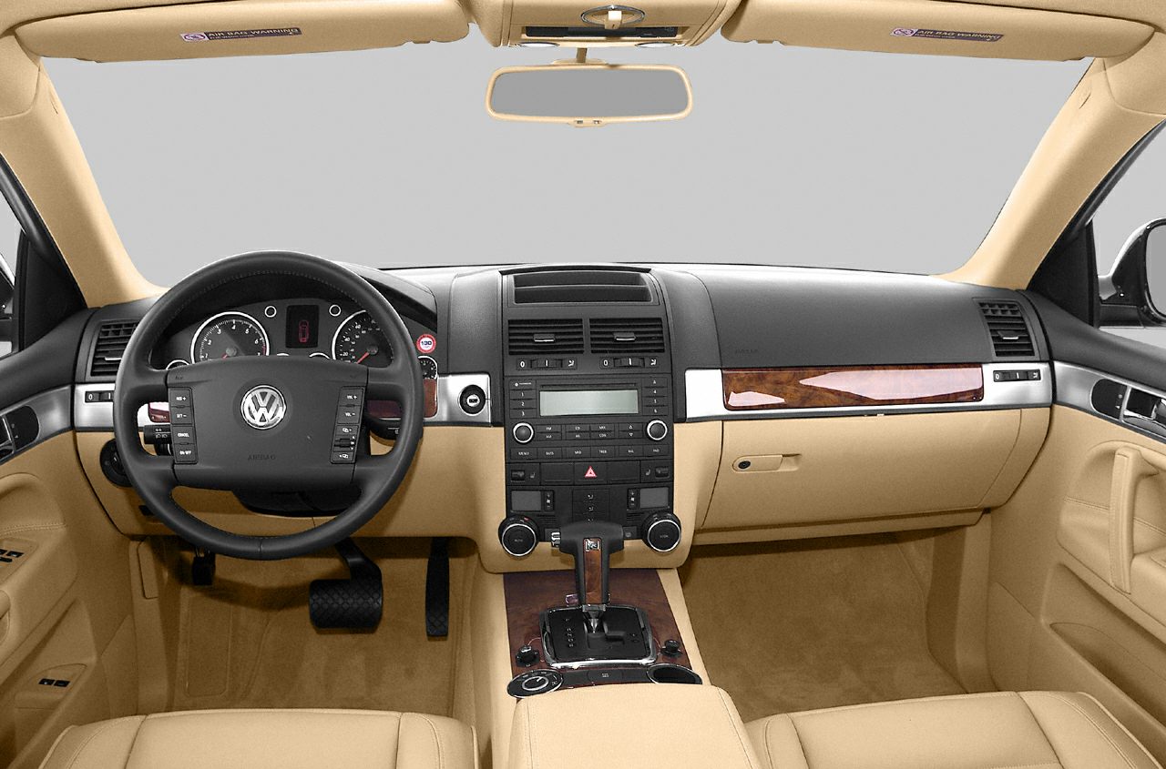 Dashboard and steering wheel with beige upholstery and wood trim