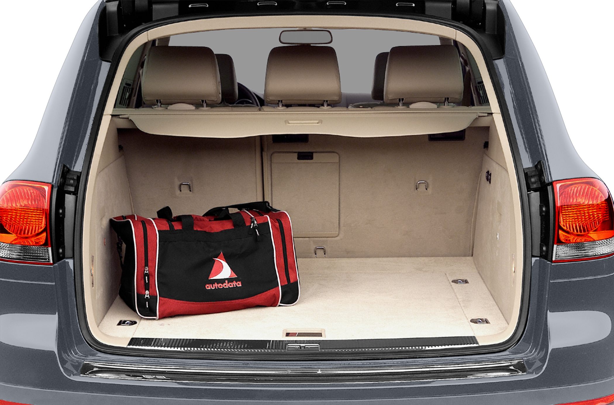 Spacious car trunk with beige interior and a red-black duffle bag