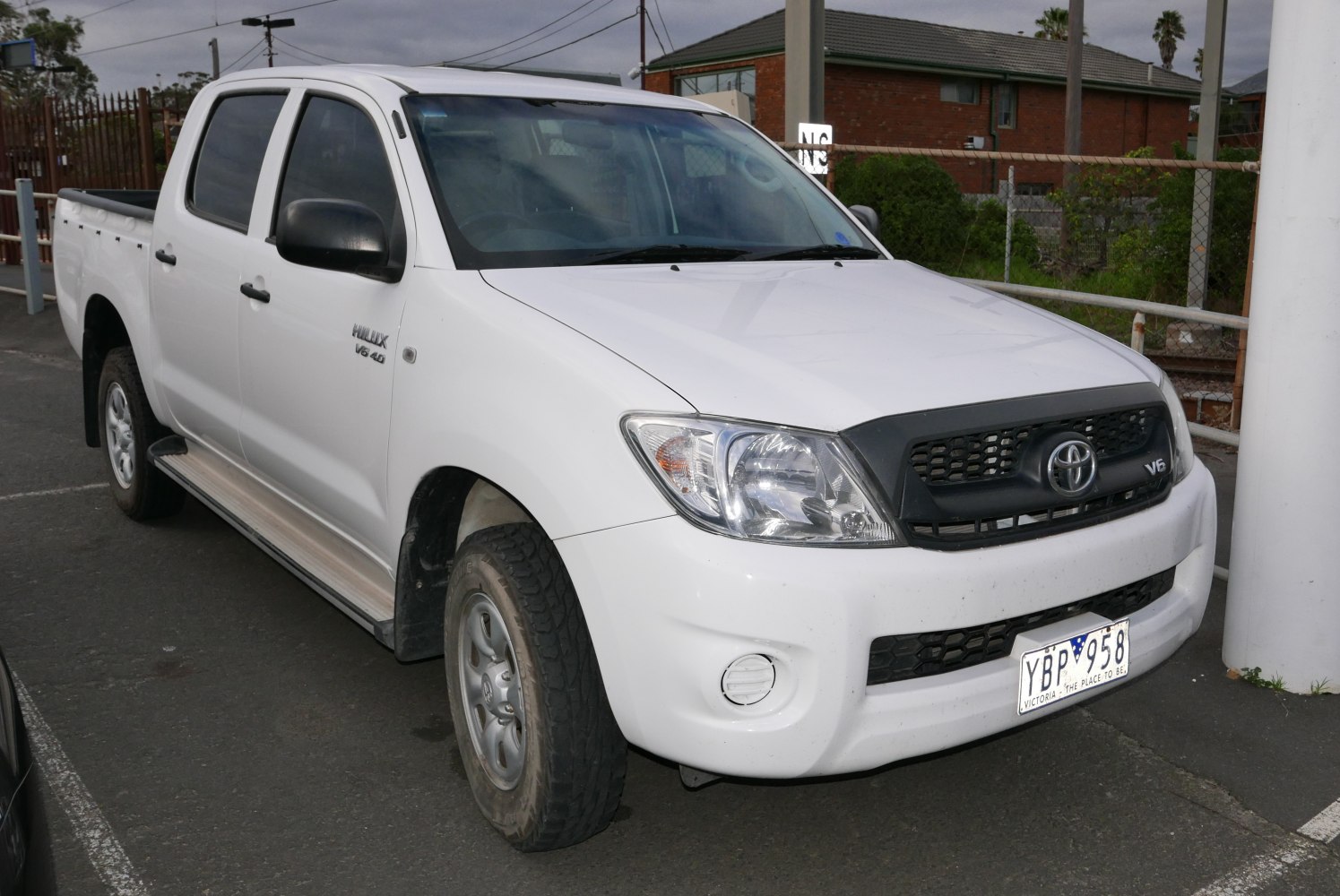 Front-side view of white pickup with V6 4.0 badge and side steps