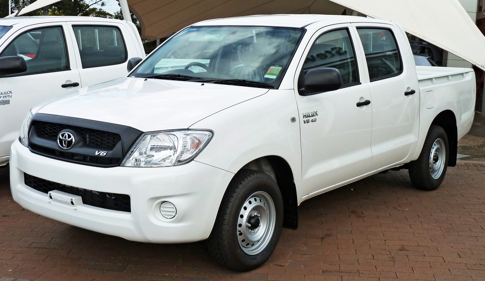 White double cab pickup with V6 badge and steel wheels