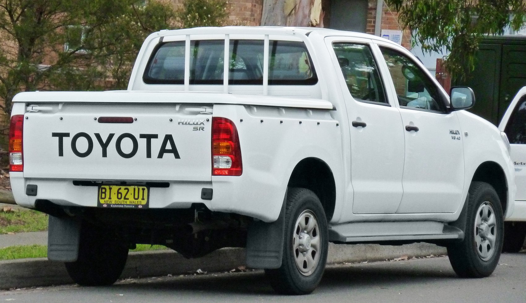 Rear view of double cab pickup with protective bars and detailed tailgate.