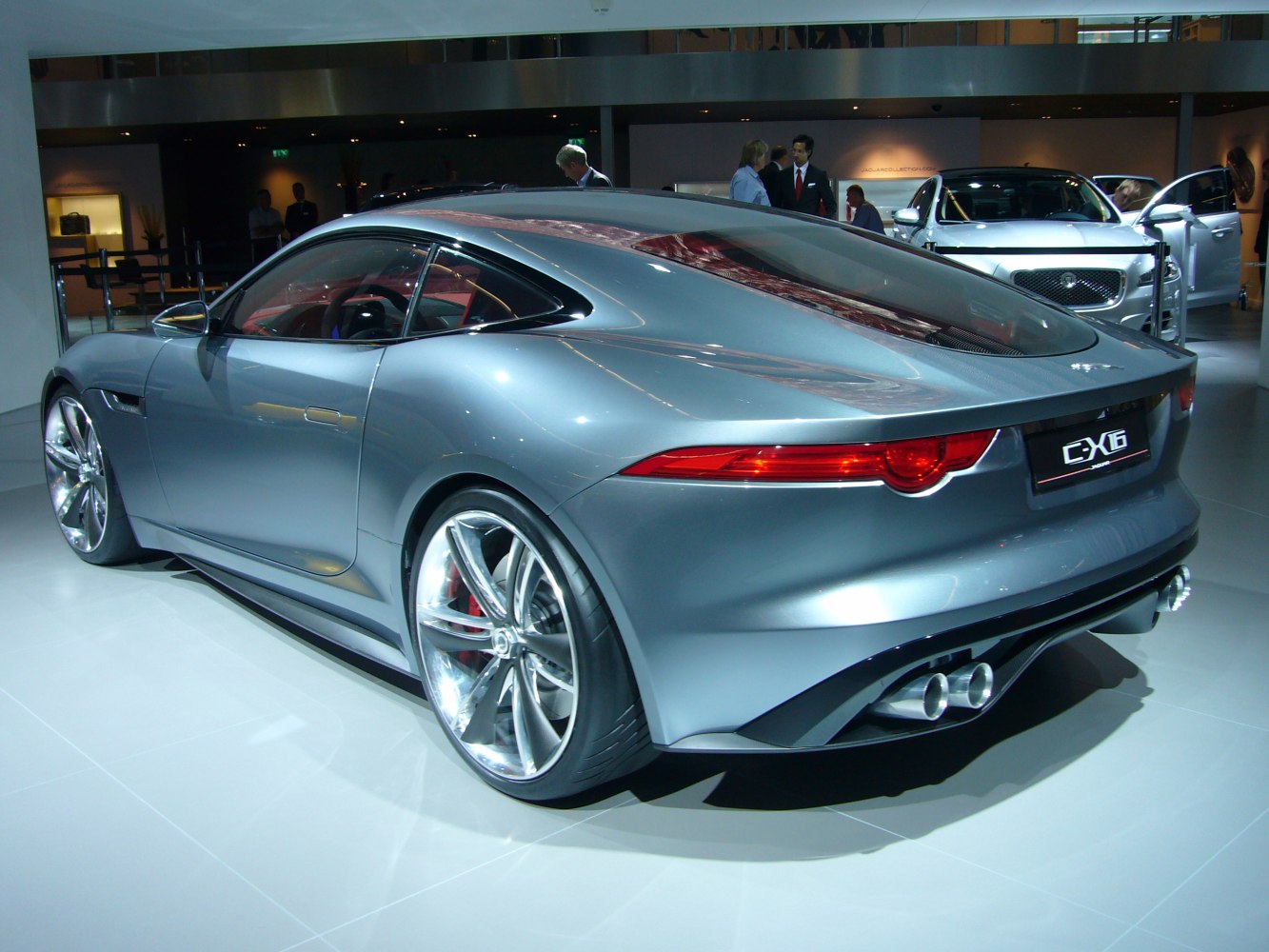 Silver coupe with aerodynamic design, dual exhaust, and chrome multi-spoke rims