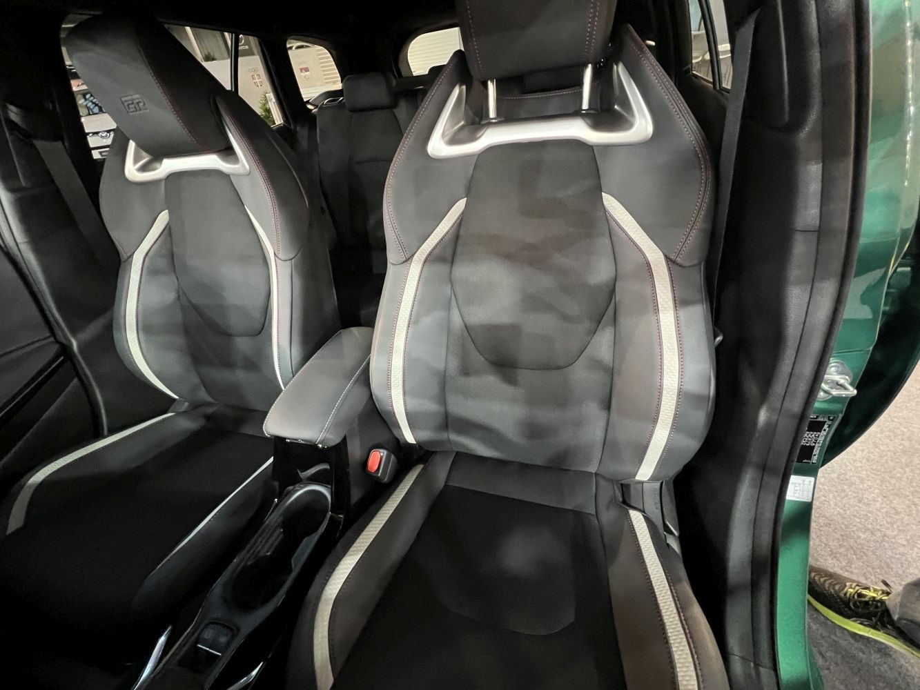 Sporty front racing seats with distinctive stitching and armrest