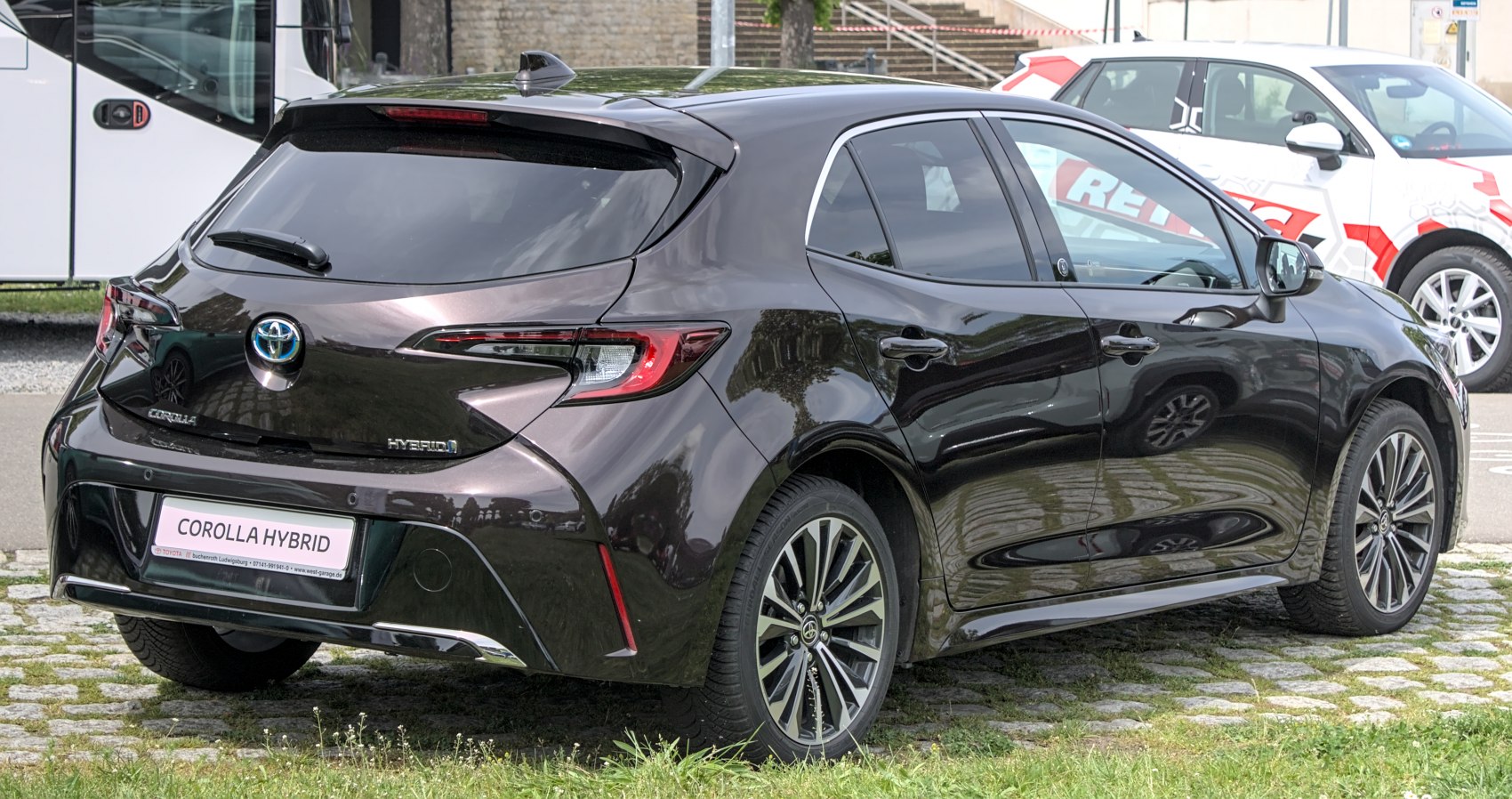 Rear view of sleek black hatchback hybrid with LED lights and alloy wheels