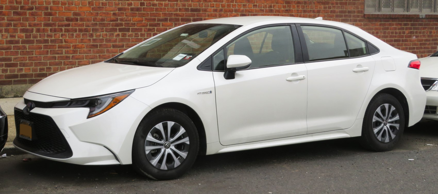 White compact sedan with aerodynamic profile and hybrid badge