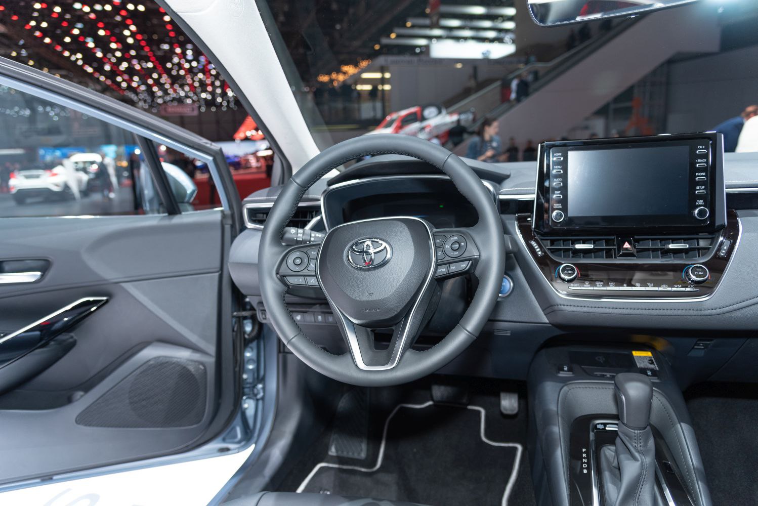 Modern car interior with dashboard, steering wheel, infotainment screen.