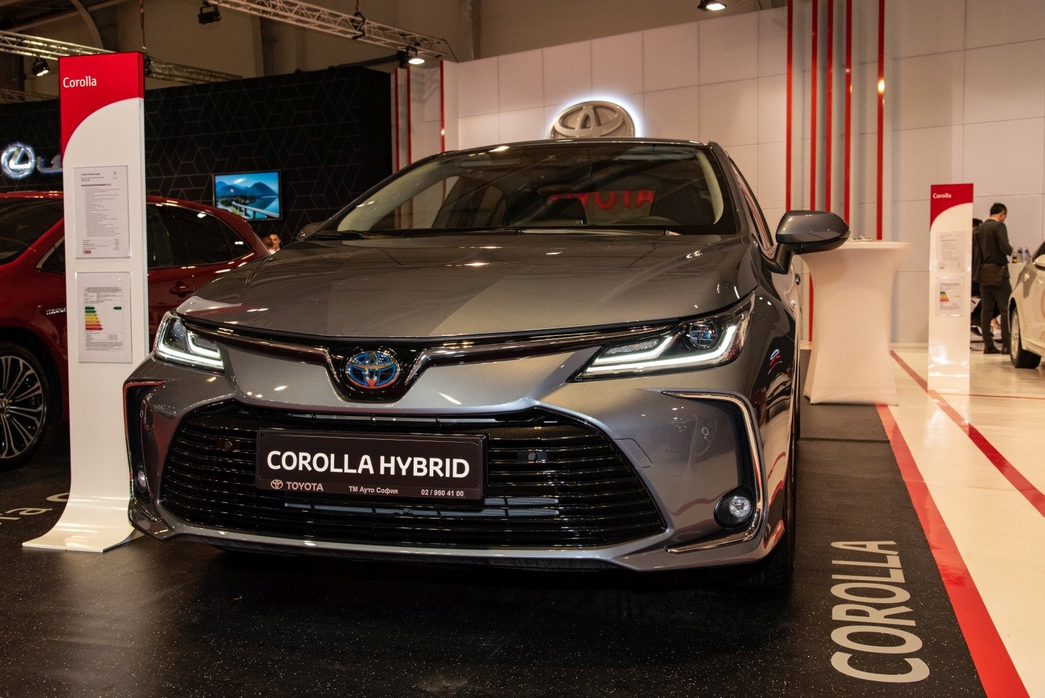 Front view with LED headlights and large black grille of a hybrid sedan.