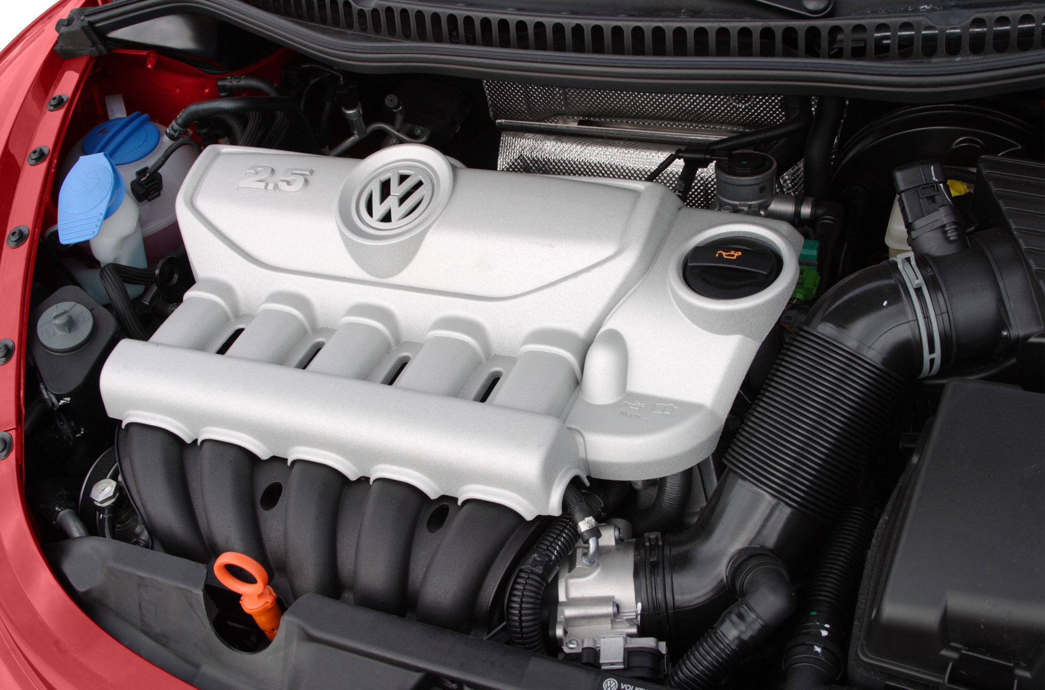 Close-up of a 2.5L engine with VW emblem and car components