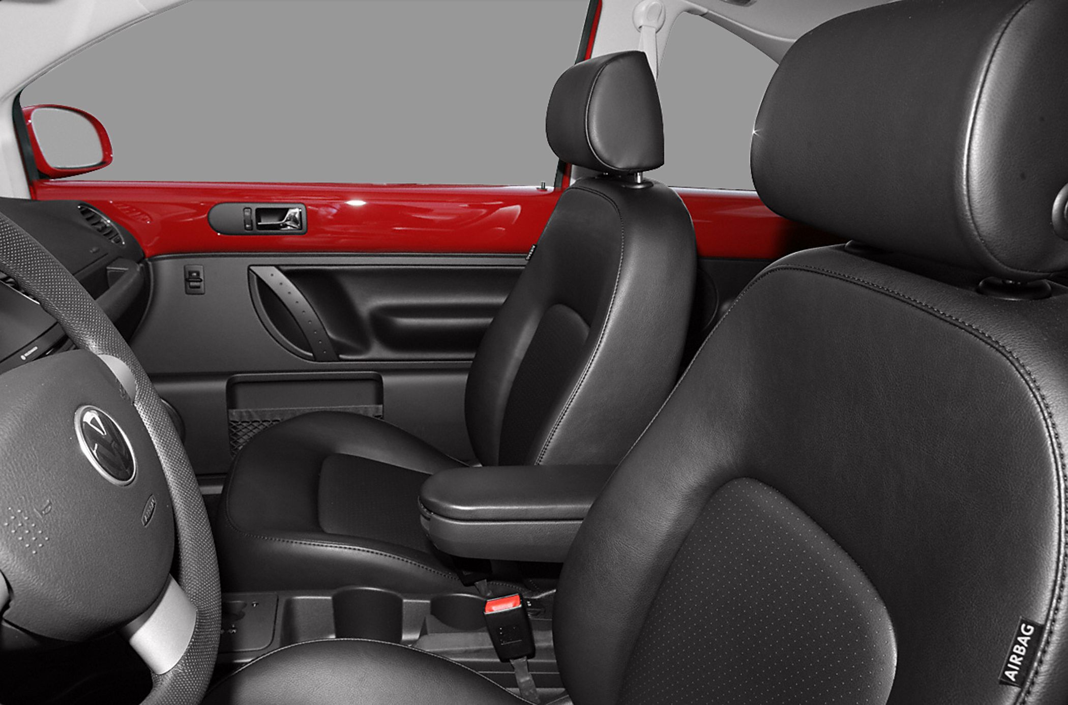 Close-up of black leather seats and red interior door trim
