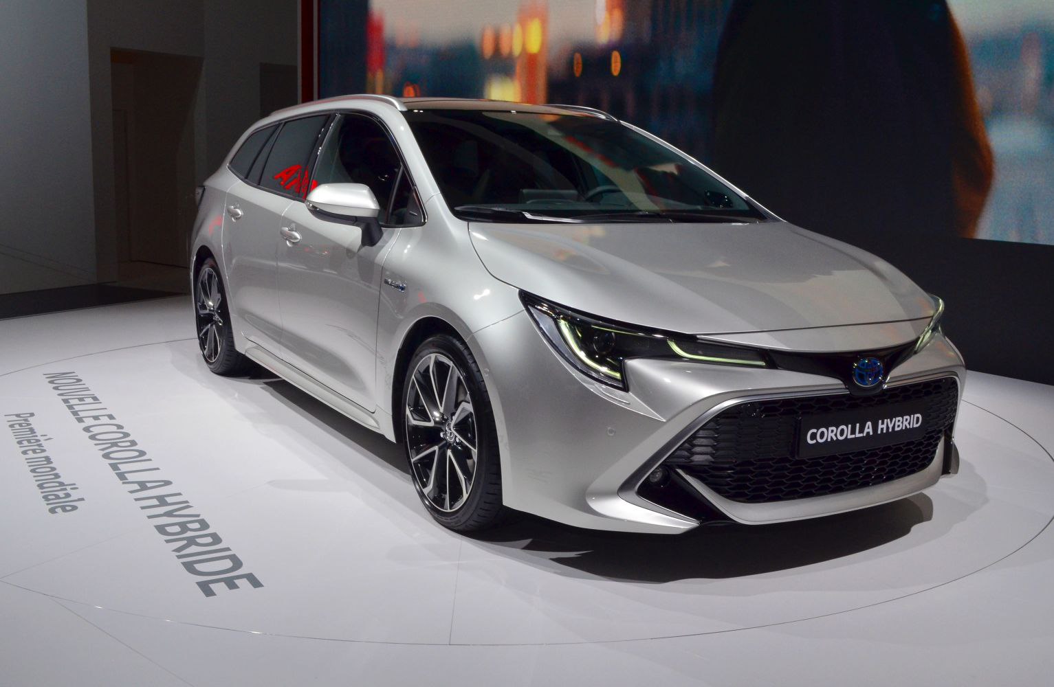 Front and side view of a silver hybrid station wagon with sleek headlights and alloy wheels