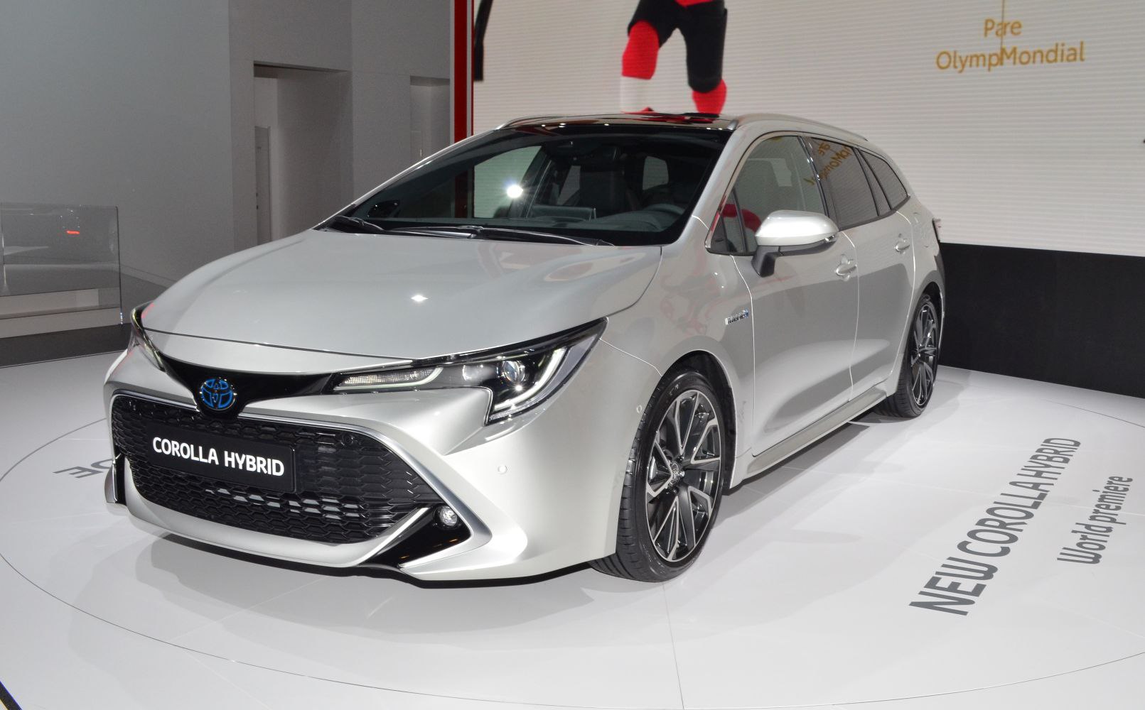 Front view of a hybrid touring sports vehicle with sleek headlights and grille
