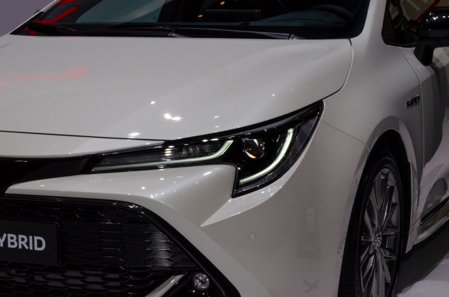 LED headlight and front grille of a hybrid hatchback with alloy wheel