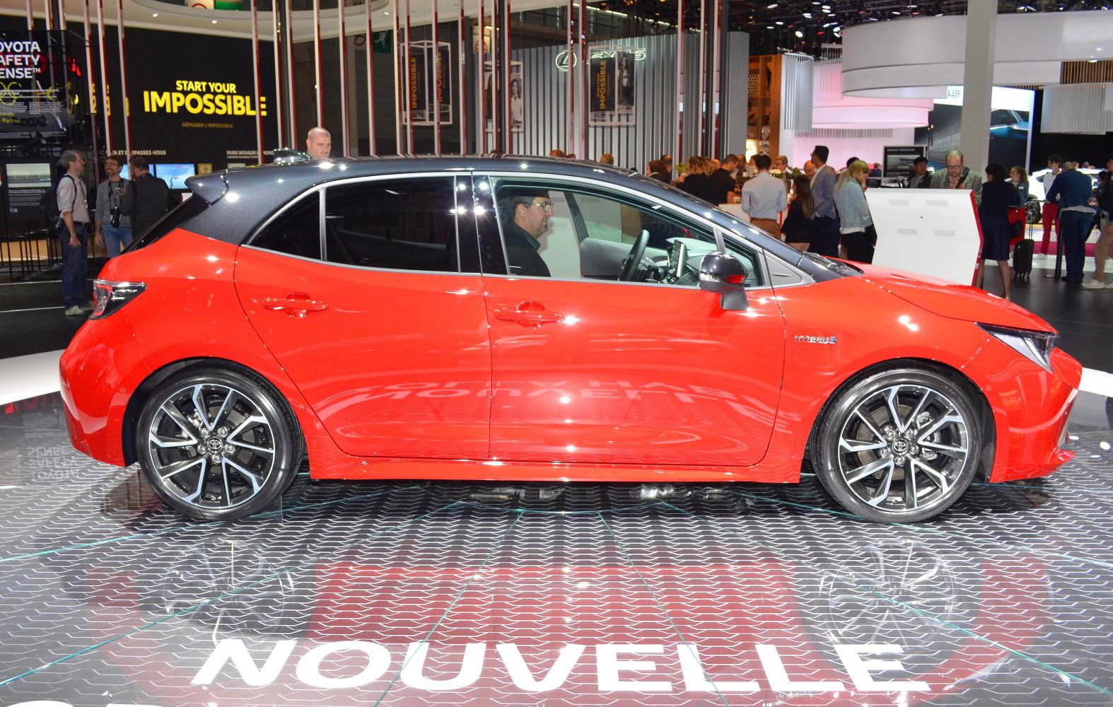 Red hatchback with black roof and sporty alloy wheels side profile