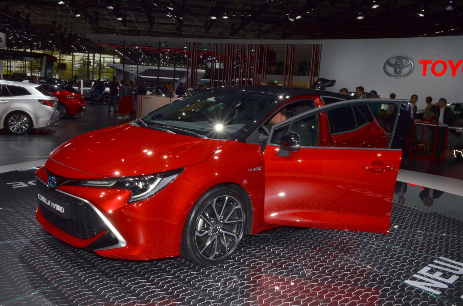 Red hatchback hybrid with open front passenger door