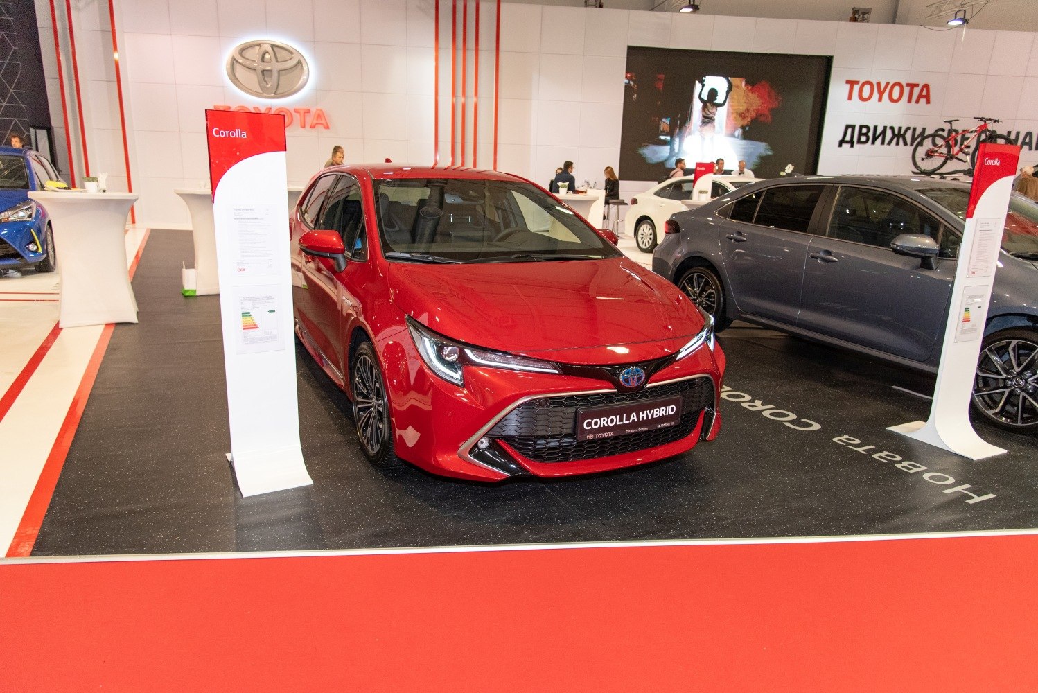 Front grille and headlights of a red hatchback hybrid car