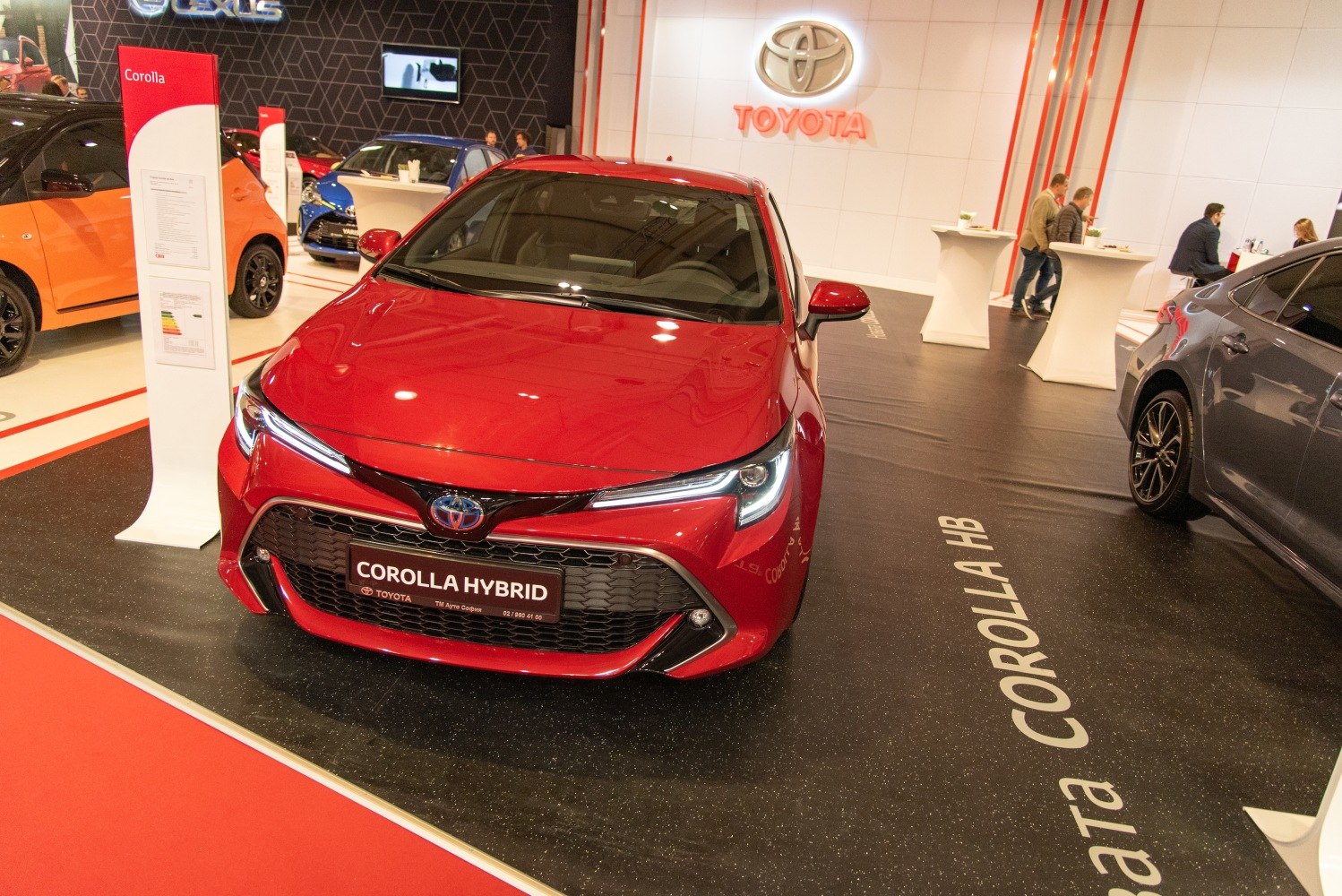 Front view of a red hatchback with LED headlights and a large grille