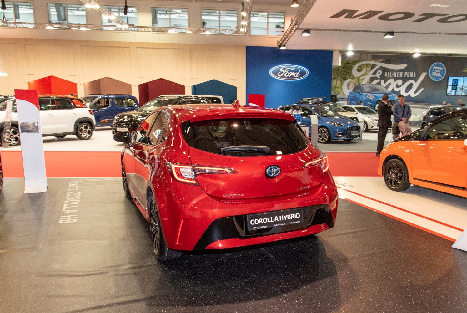 Rear view of red hybrid hatchback with distinct taillights.