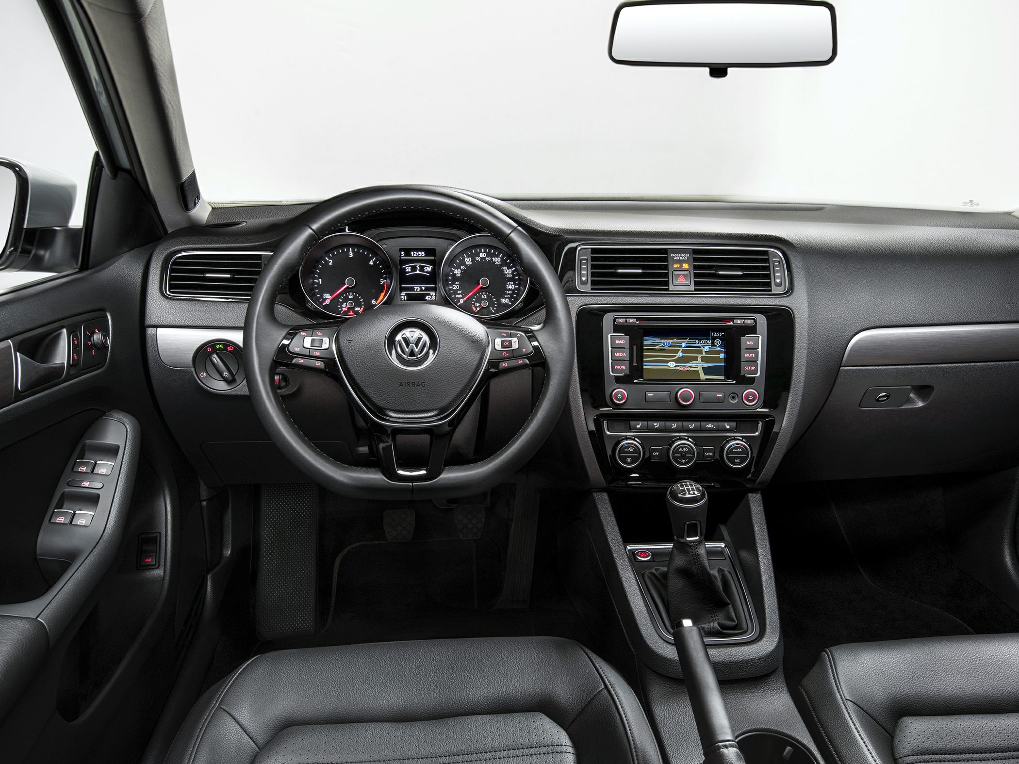Interior with manual transmission, touchscreen navigation, climate controls, and leather seats