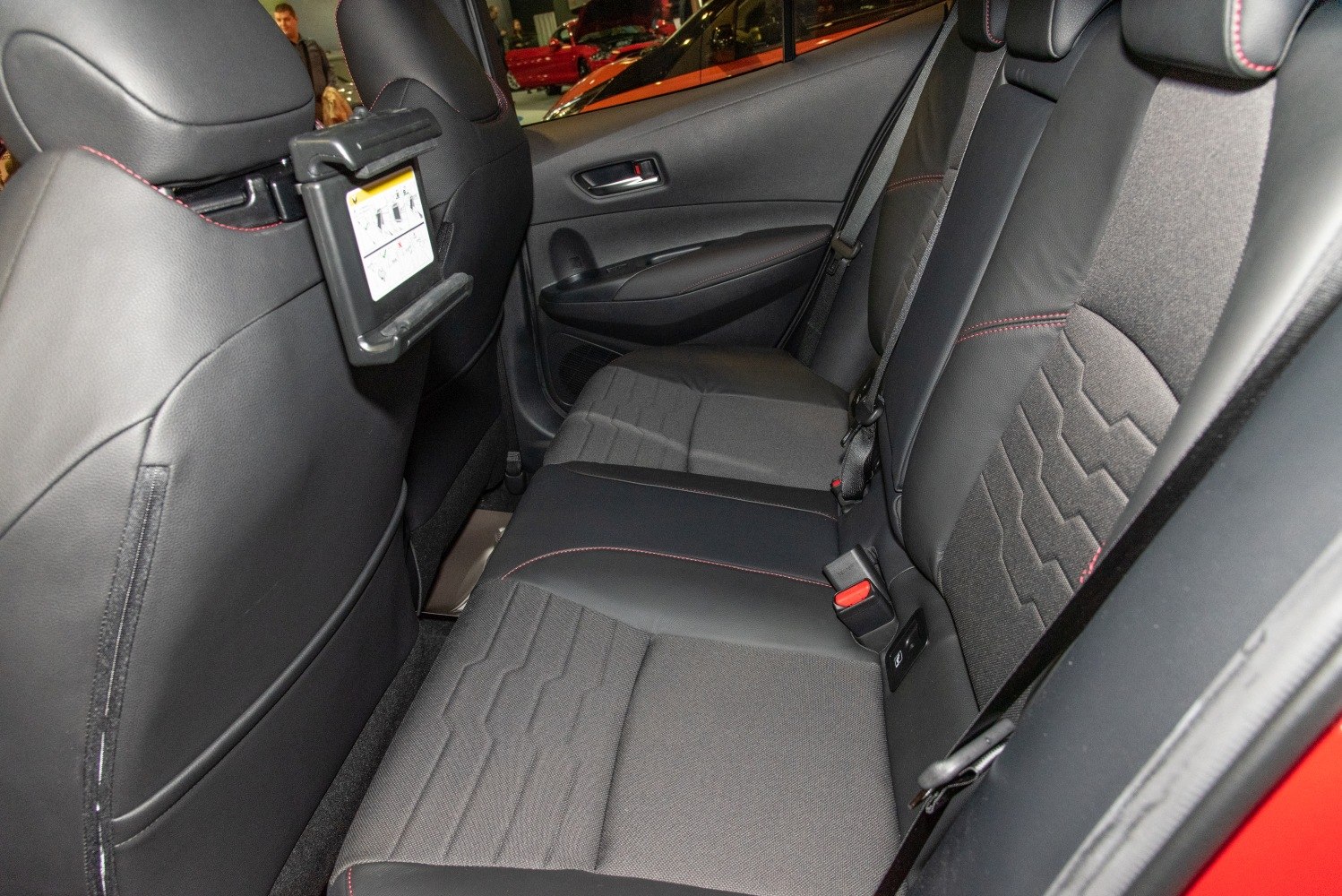 Rear seats with fabric and leather upholstery, foldable tray, and seatbelt.