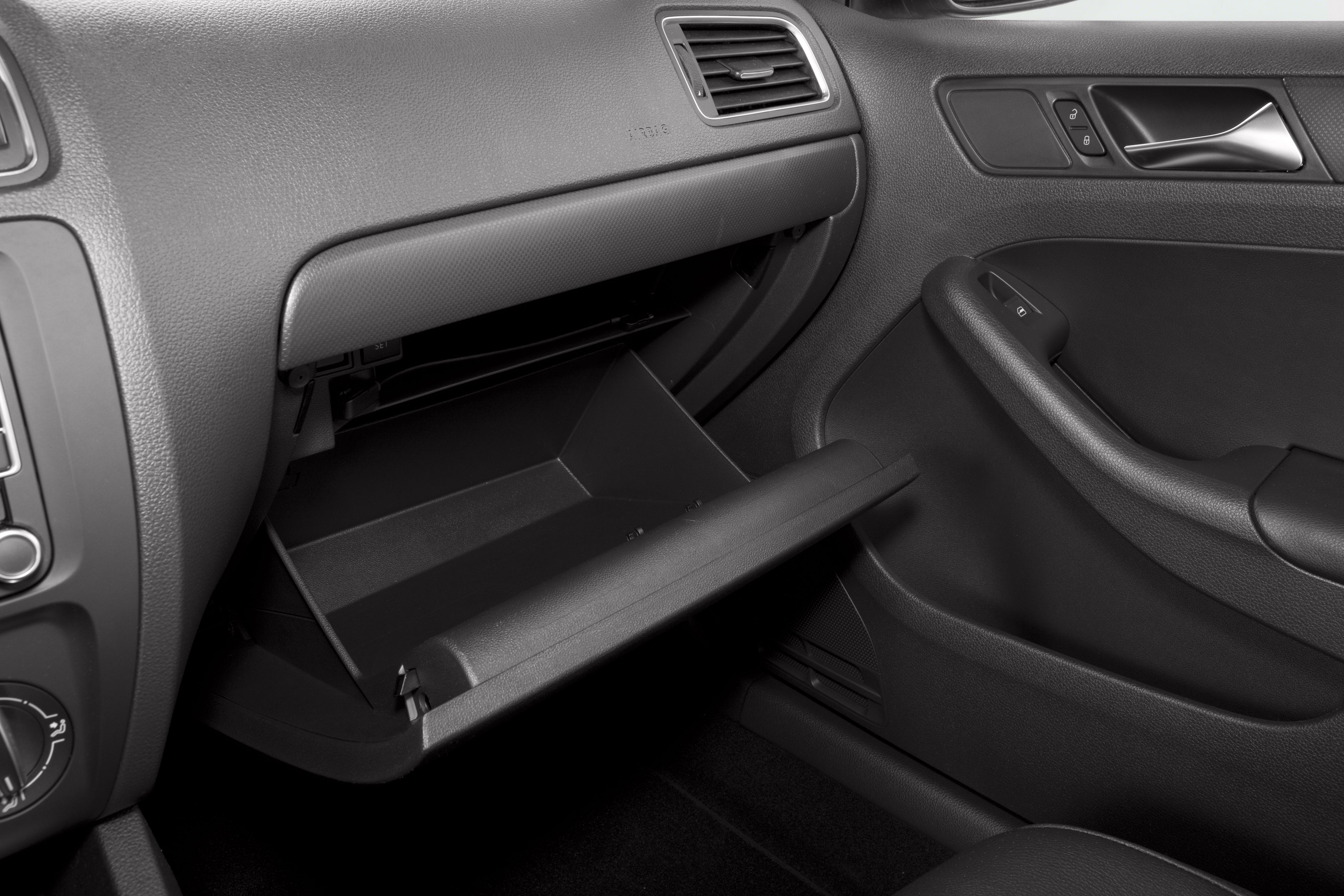 Open glove compartment and door panel with control buttons in car interior