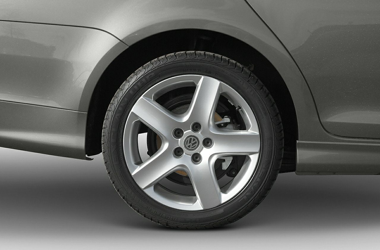 Five-spoke alloy wheel and tire with visible brake disc and VW emblem