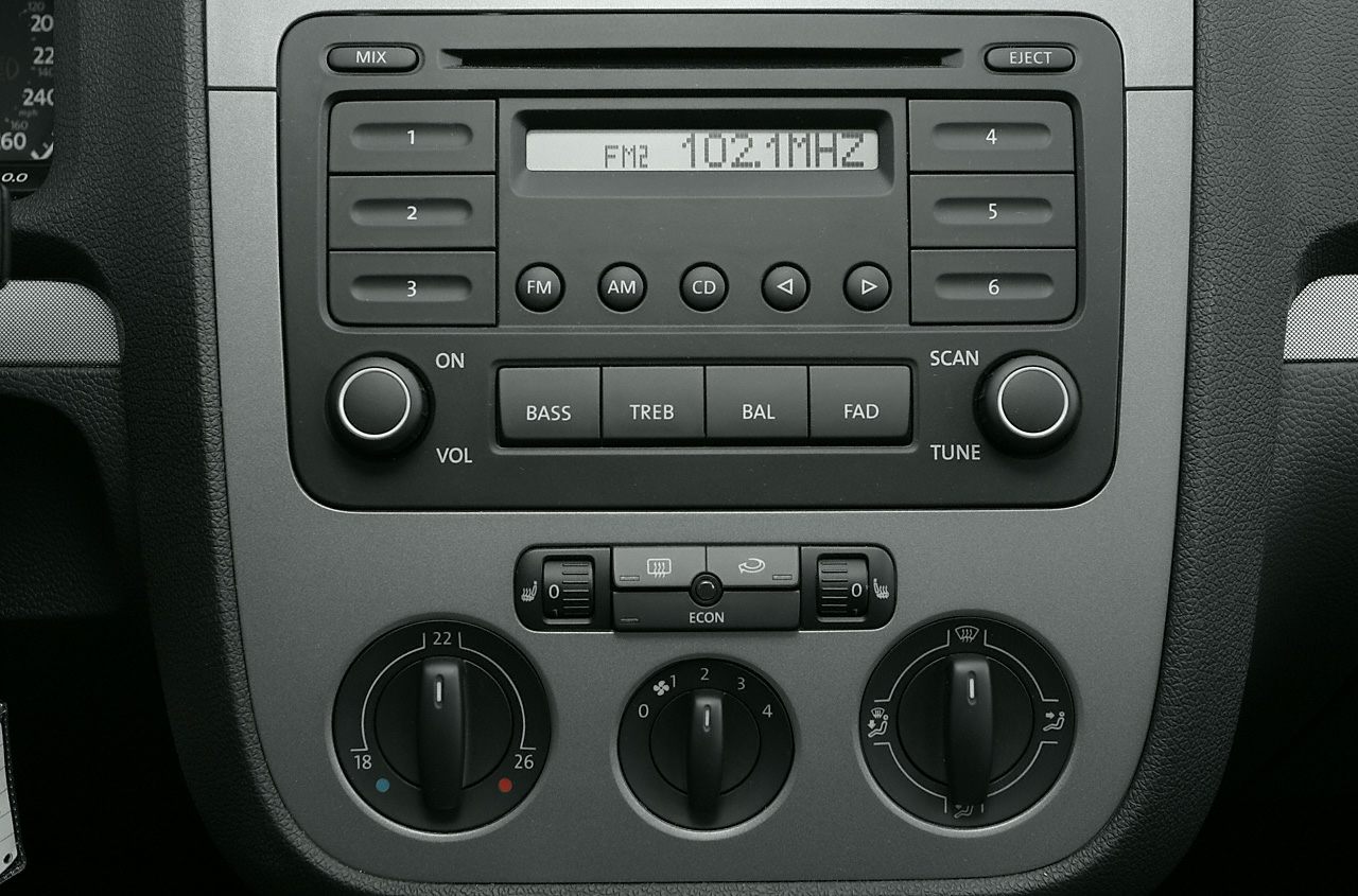 Radio unit with preset buttons and manual climate control knobs