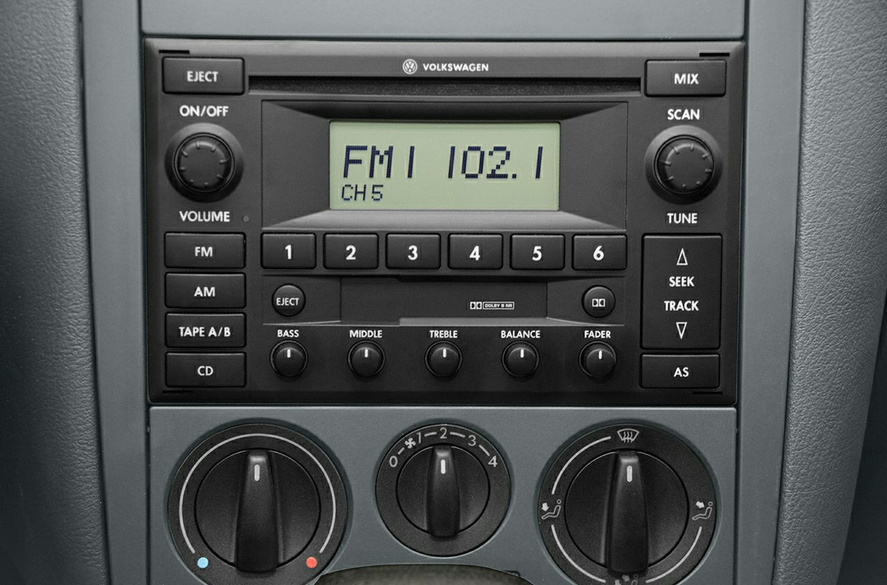 Classic radio and manual climate control knobs with FM, AM, tape, and CD options