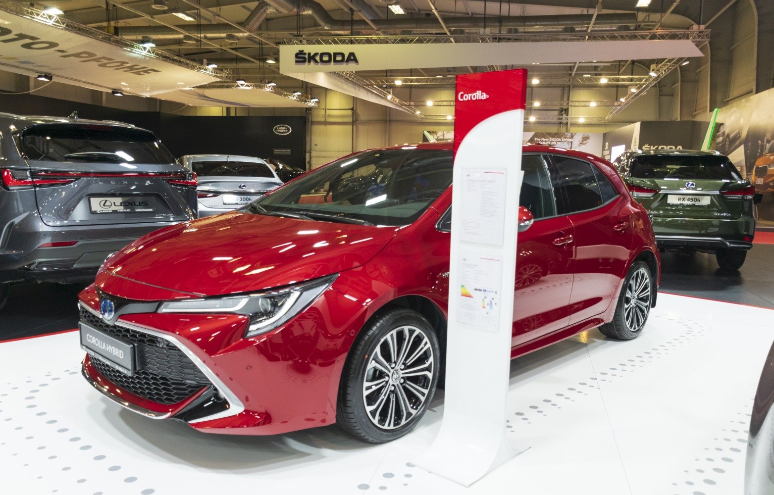 Red hatchback with sleek headlights and multi-spoke alloy wheels