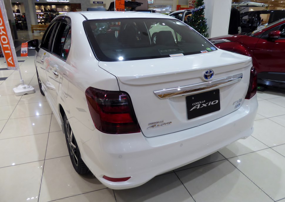 Rear view of modern sedan with dark taillights and chrome trim